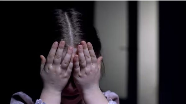 طفلة تبكي وتغطي وجهها