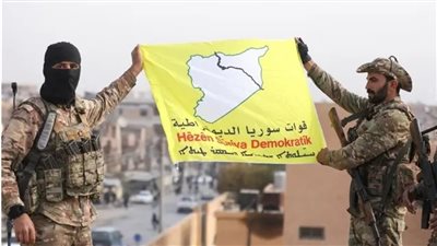 عناصر يرفعون شعار قوات سوريا الديمقراطية 